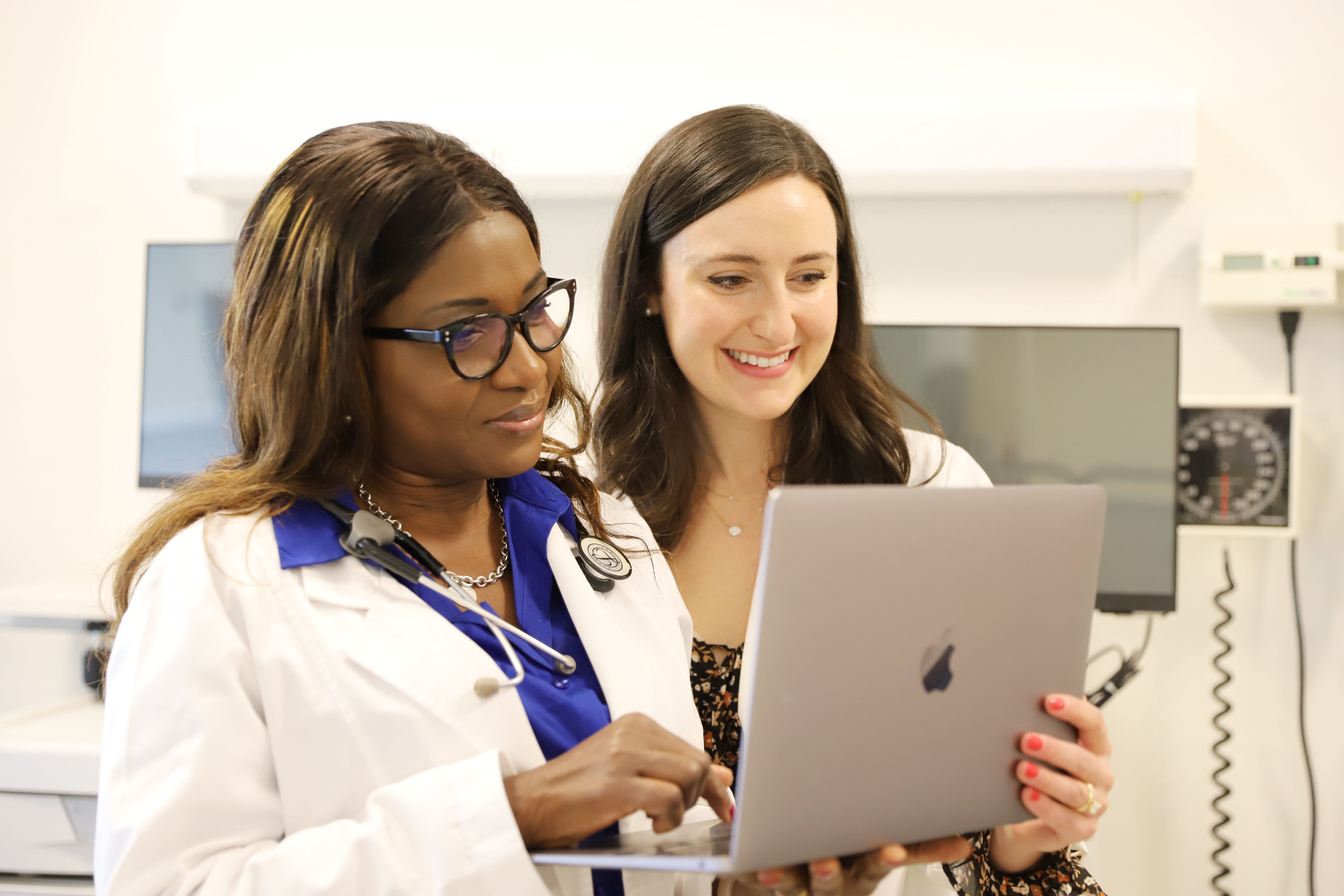 two female DNP students looking at a laptop screen